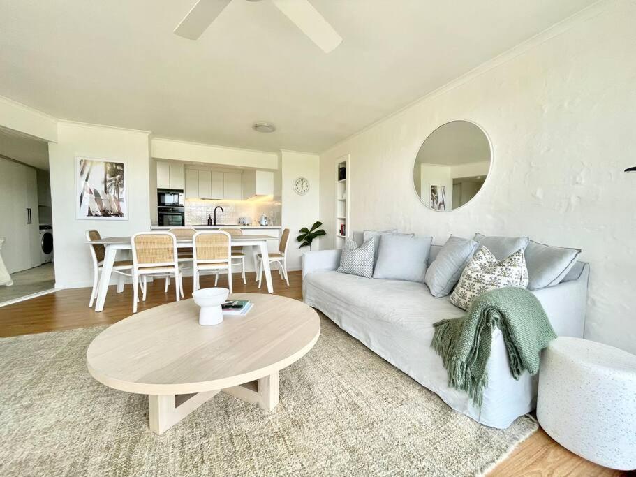 a living room with a white couch and a table at Surfrider - Beach front apartment with pool in Byron Bay