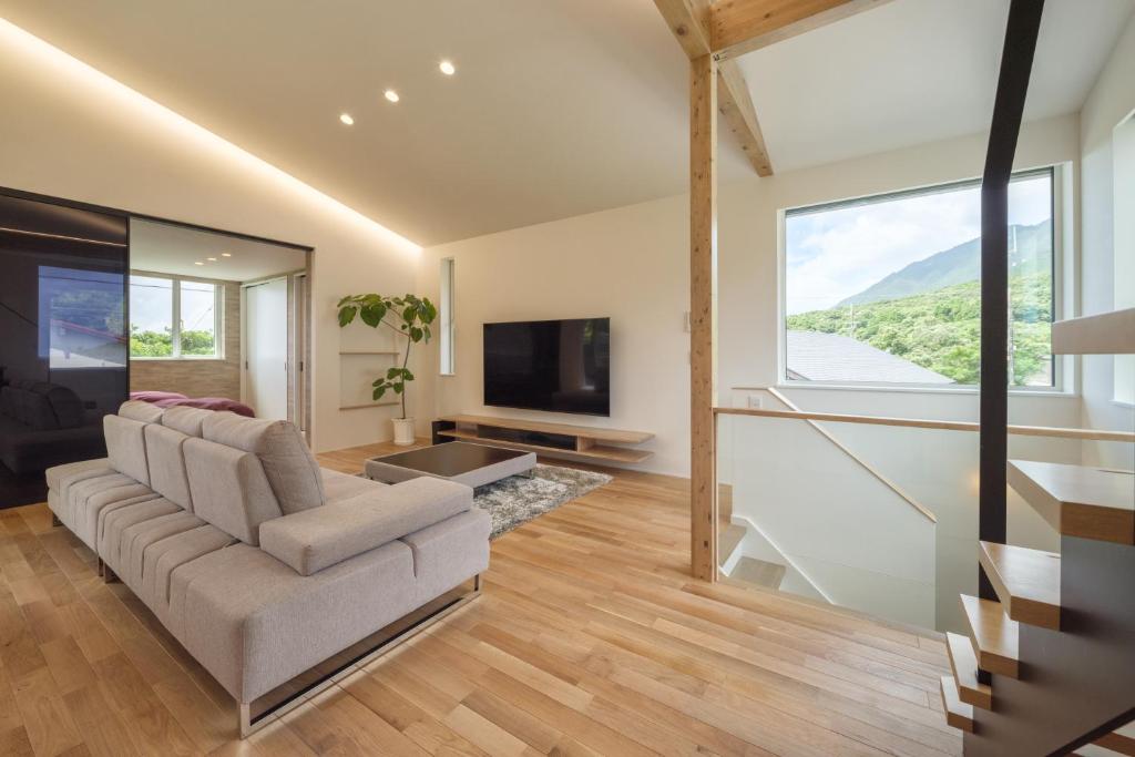 a living room with a couch and a television at KeiU-Yakushima Luxury Guest House in Yakushima