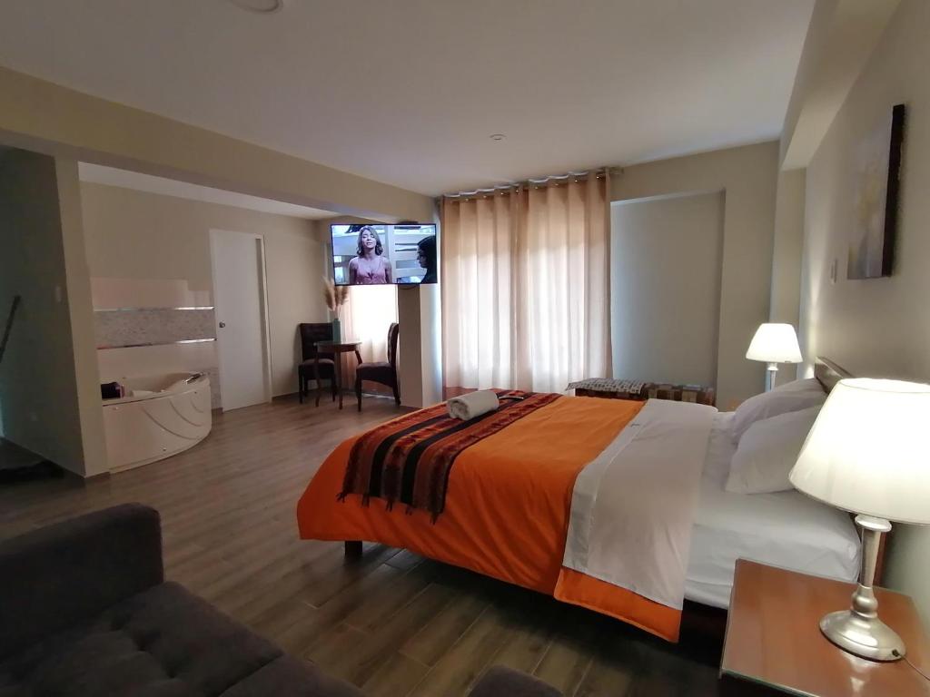 a hotel room with a bed and a flat screen tv at Los Ángeles Suite Hotel in Chavín de Huantar