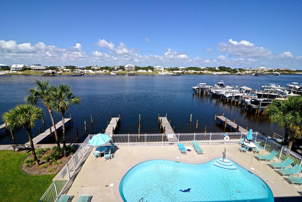 a large swimming pool next to a marina with boats at Dolphin Harbor 3C in Orange Beach