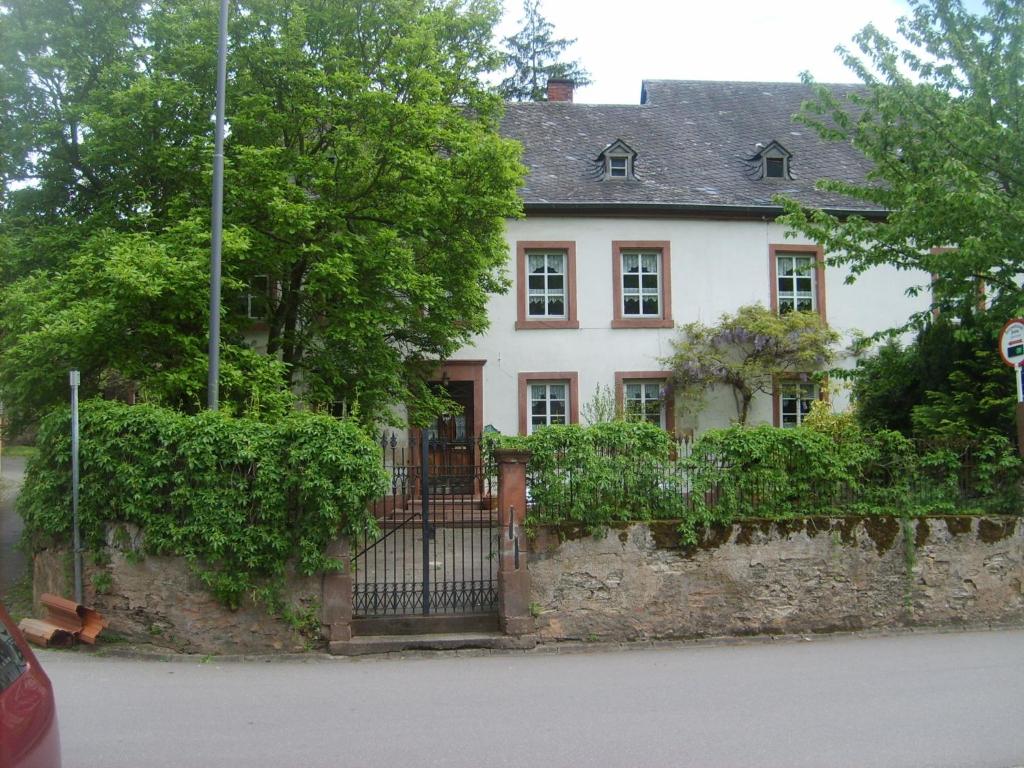 a white house with a fence in front of it at Ferienwohnung Jüngling in Neumagen-Dhron