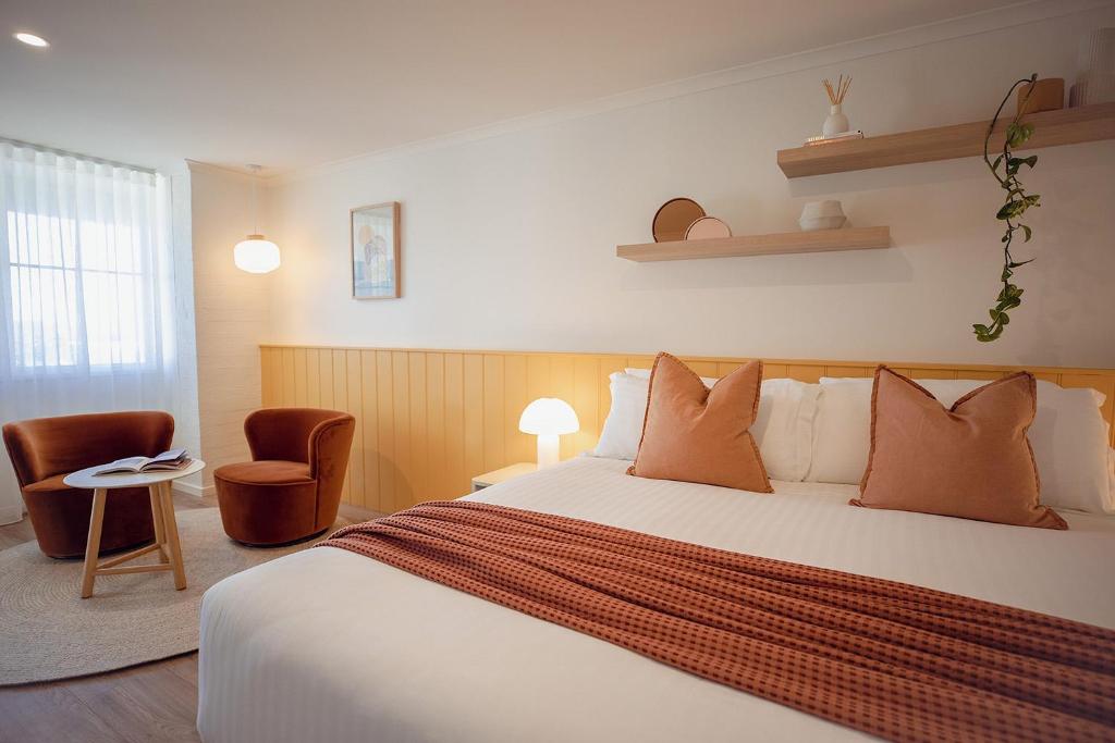 a hotel room with a bed and two chairs at Sunnymead Hotel in Aireys Inlet