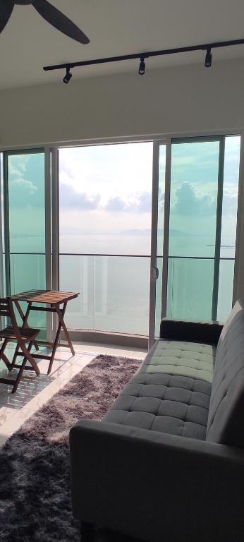 een woonkamer met een bank en een tafel bij Infinite Seaview with Penang Bridge Suite with Sunrise up to 11 person in Bayan Lepas