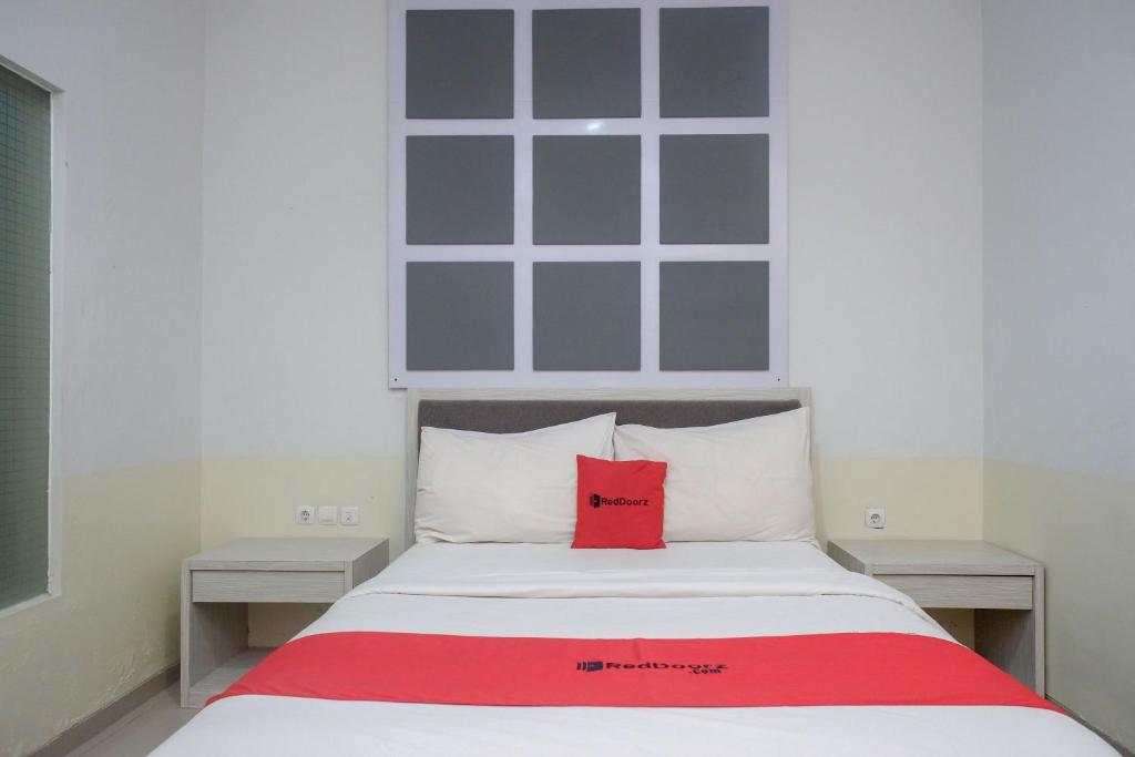 ジョグジャカルタにあるRedDoorz near Jogja City Mallのベッド(上に赤い枕付)