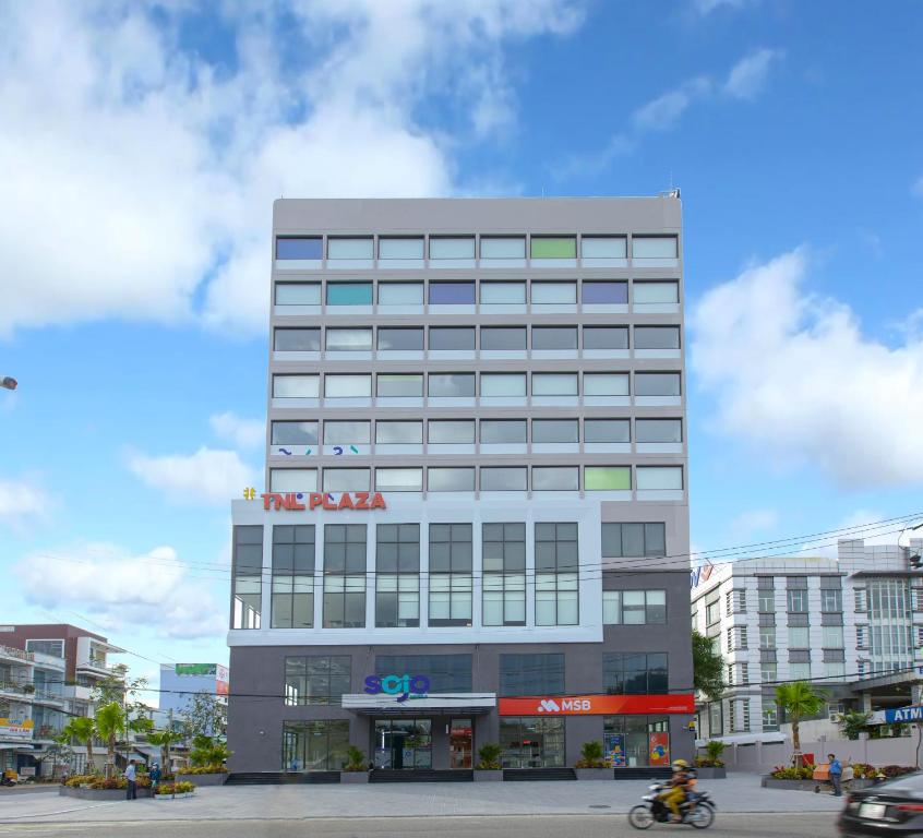 um edifício alto com um sinal em cima em SOJO Hotel Hau Giang em Vị Thanh