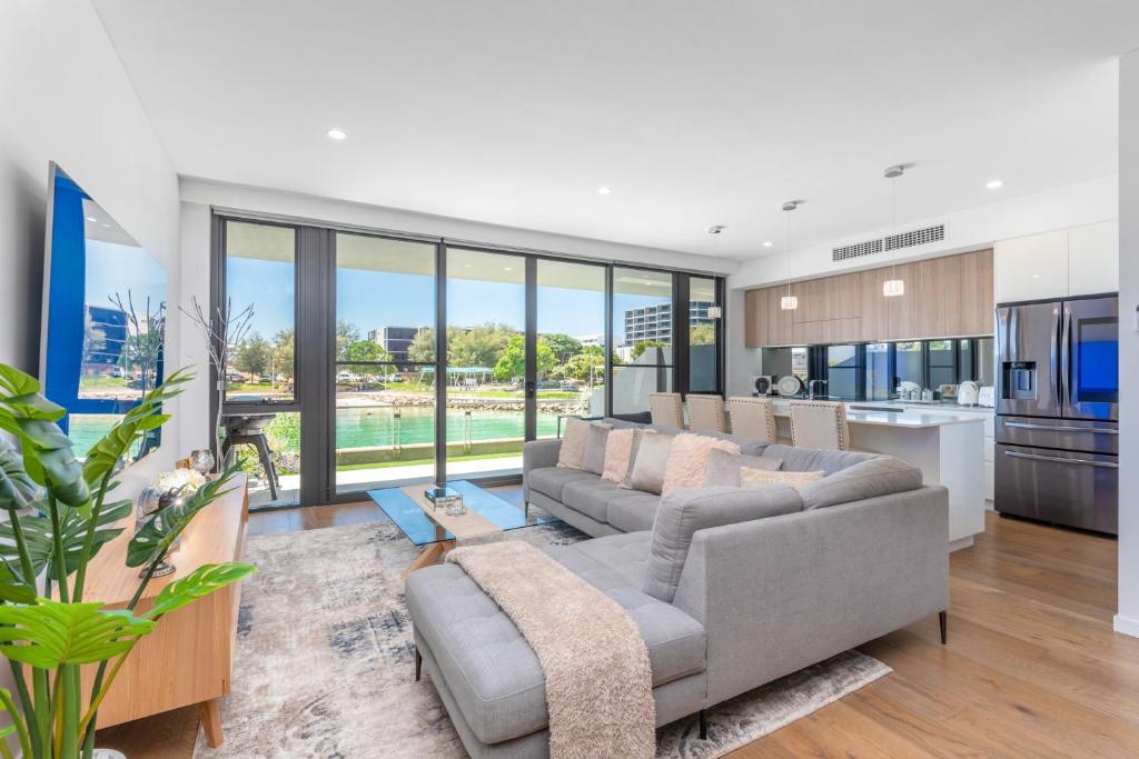 a living room with two couches and a kitchen at Maraboo Island Beachfront Villa in Fremantle