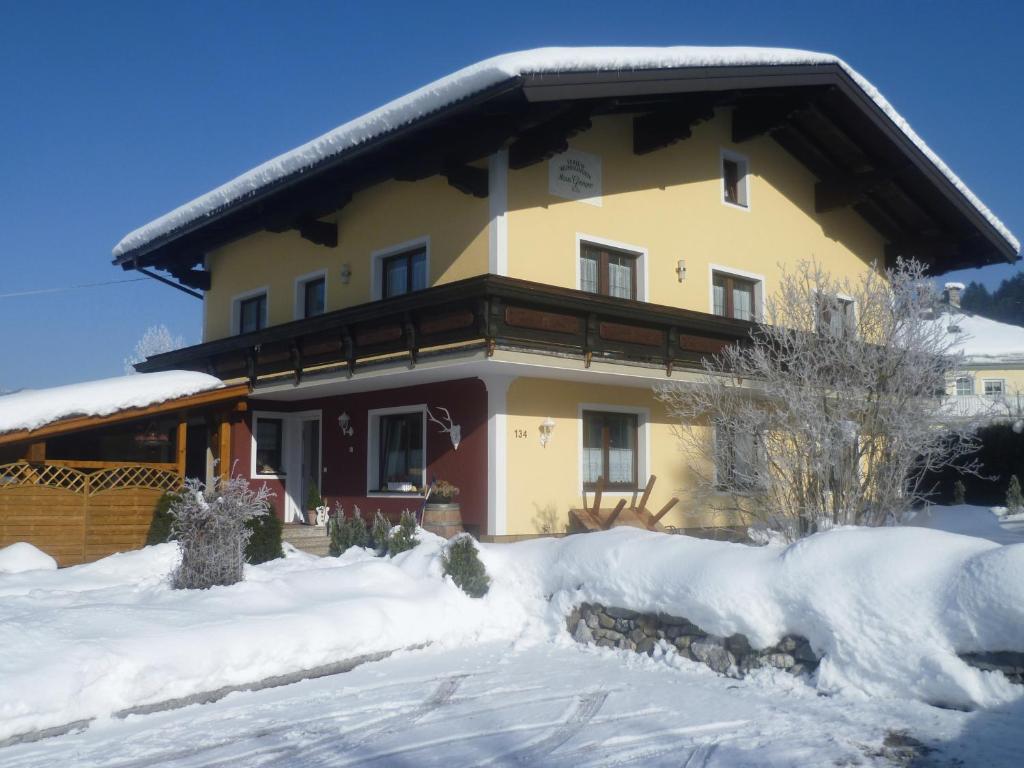 ein großes Haus mit Schnee auf dem Boden in der Unterkunft Haus Gsenger in Abtenau