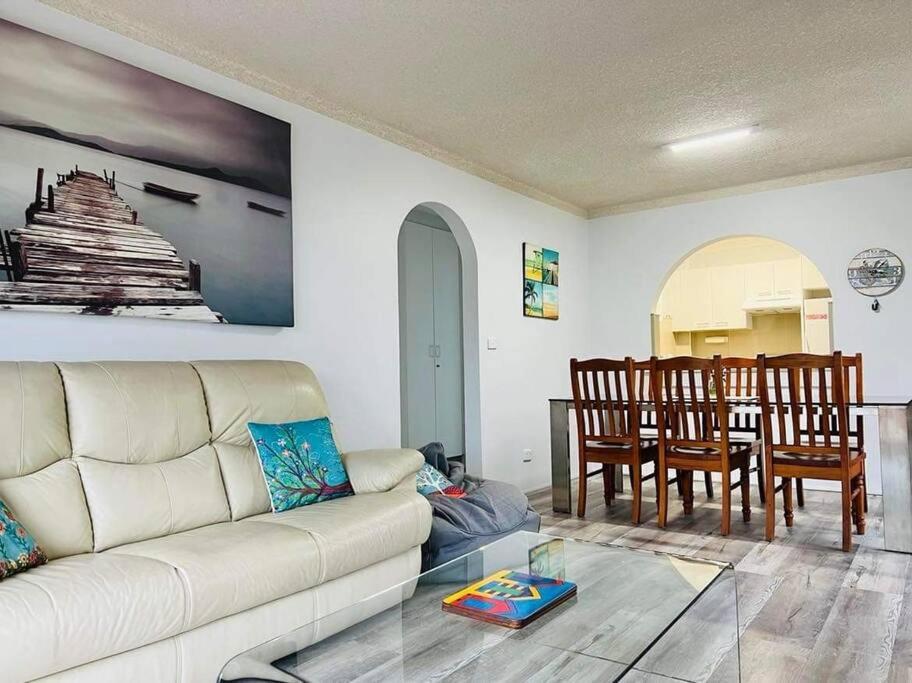 a living room with a couch and a dining room at Beachside spacious unit 9 in Tuncurry
