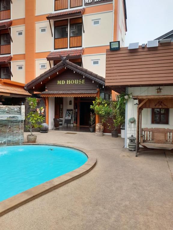 a hotel with a swimming pool in front of a building at MD House in Chiang Mai