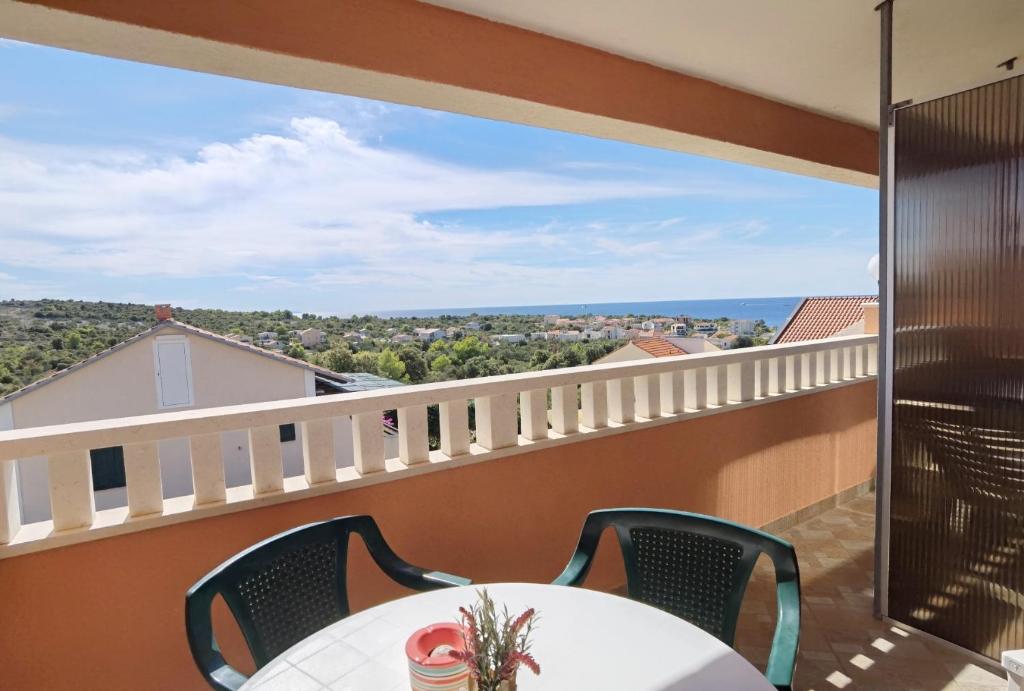 a balcony with a table and chairs and a view of the ocean at Apartments Jera- barbecue in Sevid