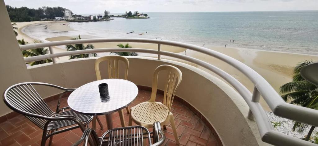 un tavolo e sedie su un balcone con vista sulla spiaggia di Tanjung tuan regency private PD a Port Dickson