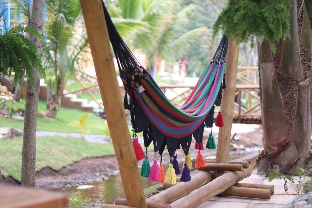 a hammock in a park with palm trees at Hotel Villa Babaçu in Jacobina