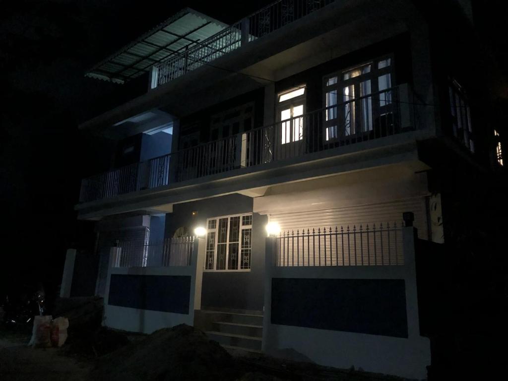 une maison avec deux fenêtres et un balcon la nuit dans l'établissement Sherpas Enclave, à Kalimpong