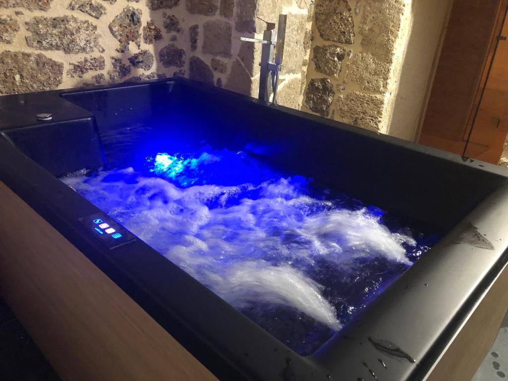a bath tub filled with blue water with clouds in it at Villagio inn Suite & Spa in Soúlion