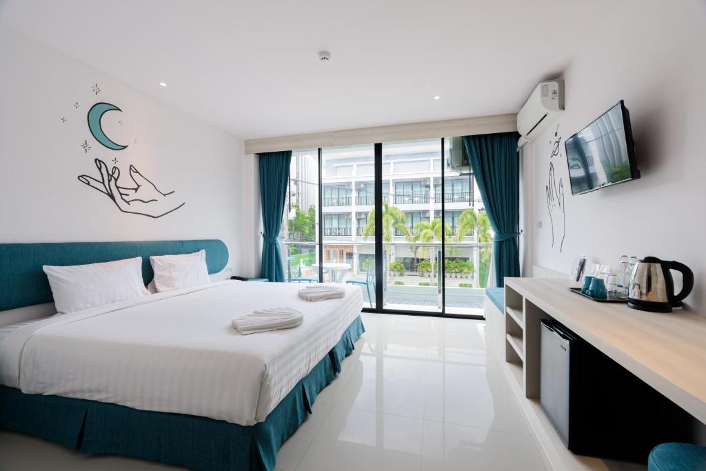 a hotel room with a bed and a large window at Moon Budget Hotel in Ao Nang Beach