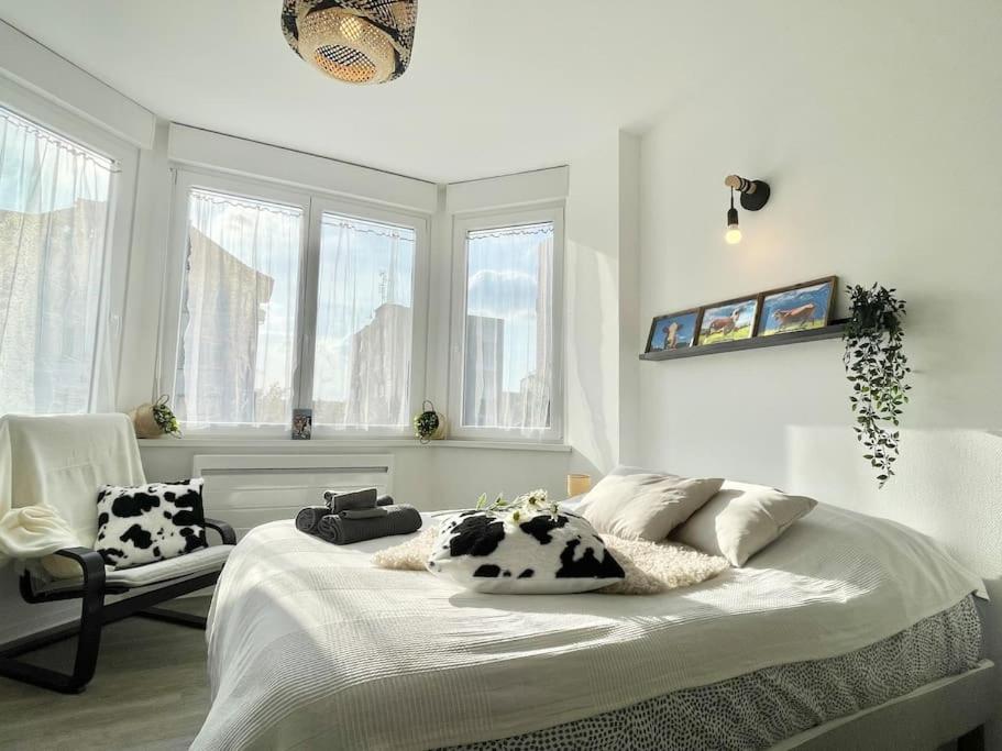 1 dormitorio blanco con almohadas de vaca en una cama en LA MASCOTTE en Saint-Louis
