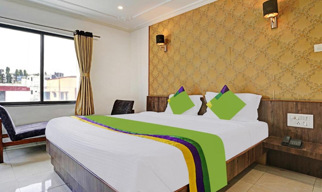 a hotel room with a large bed and a window at Treebo Trend Varsha Palace in Aurangabad