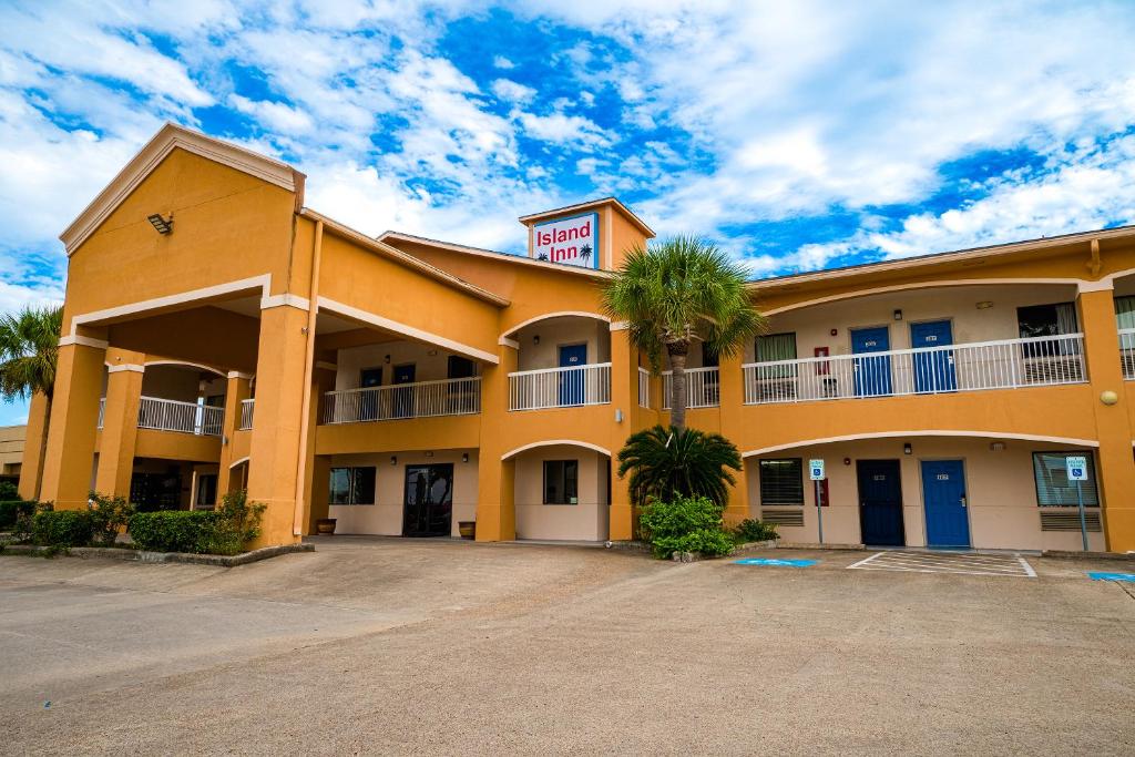 un hotel con una palmera delante en Island Inn By OYO Galveston Beach, TX en Galveston