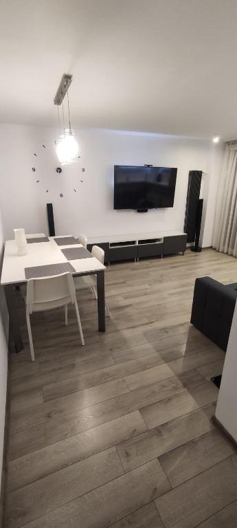 uma sala de estar com uma mesa e uma televisão de ecrã plano em Apartament CENTRUM em Sosnowiec