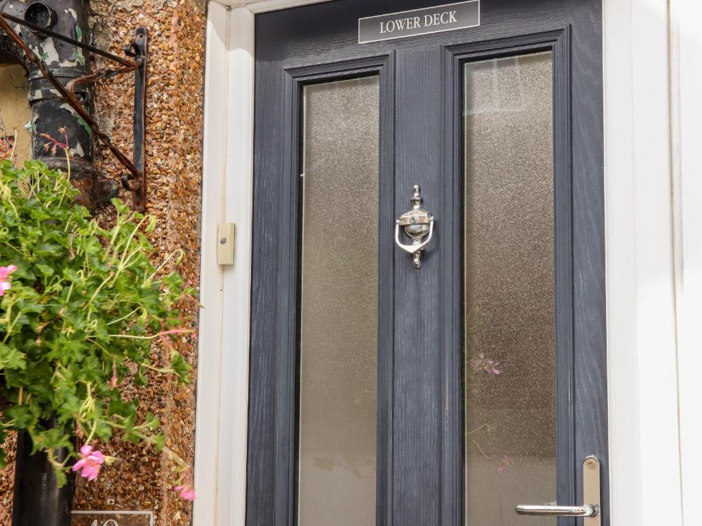 a black door with a sign on it at Lower Deck in Bexhill