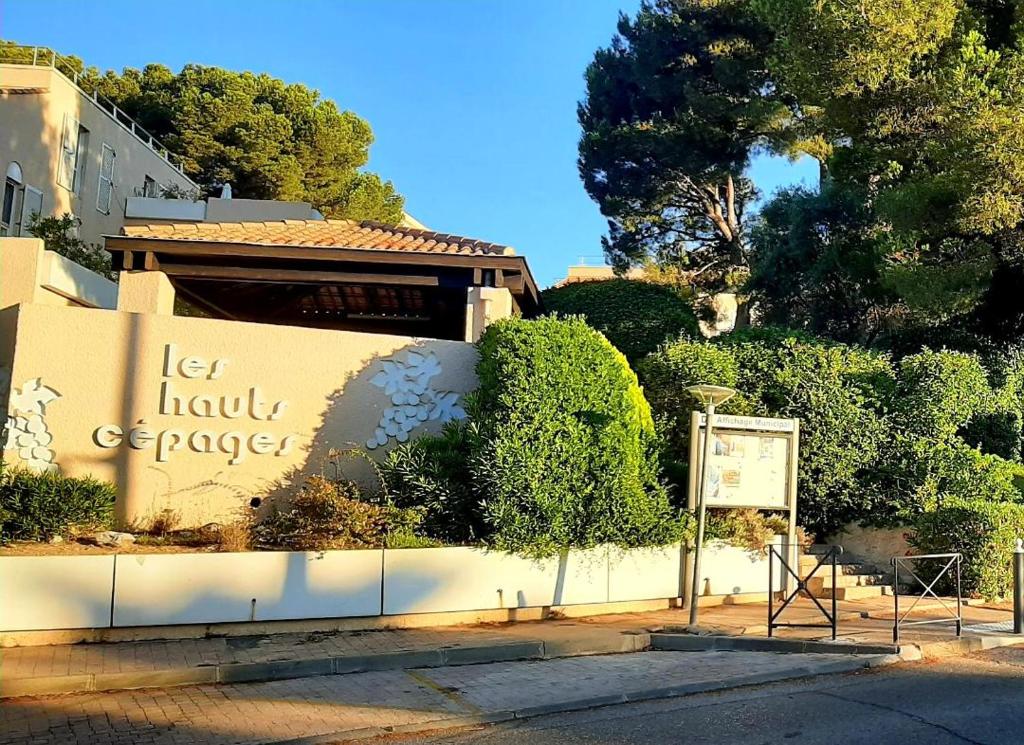 a building with a sign on the side of a street at Chambre hôte Residence sous les pins in Cassis