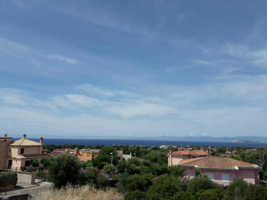 a view of a town with the ocean in the background at Villa delle Gazanie -Camera in villa -Vista panoramica sul Golfo in Quartu SantʼElena