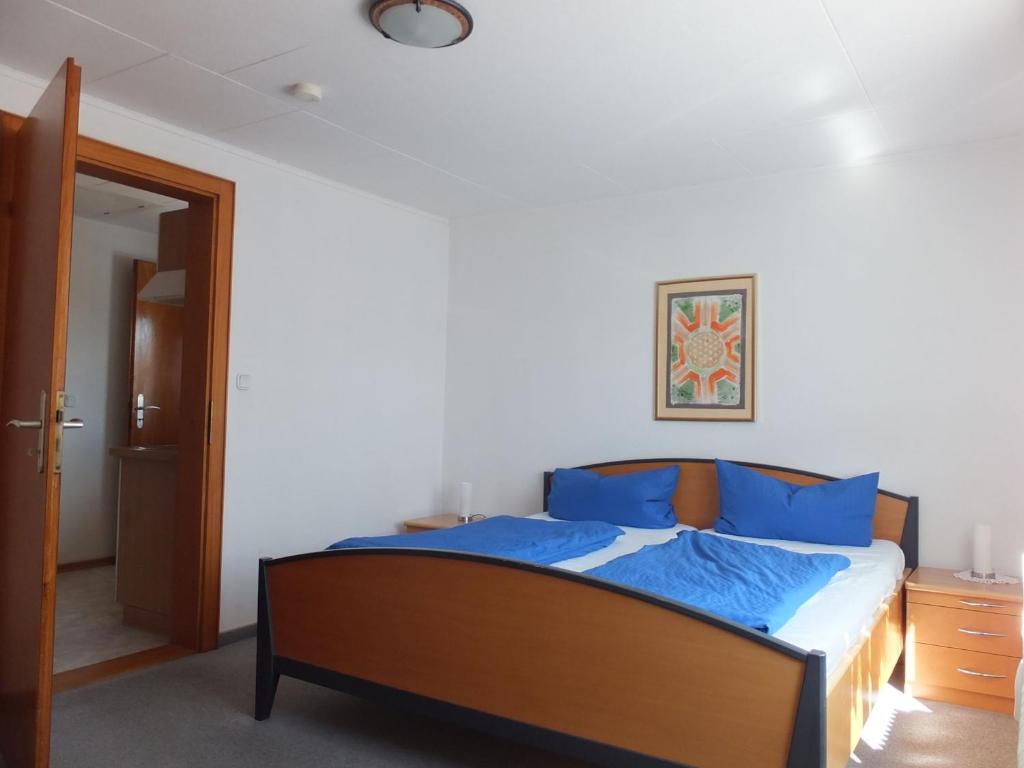 een slaapkamer met een bed met blauwe kussens bij Haus Alpenblick in Immenstaad am Bodensee