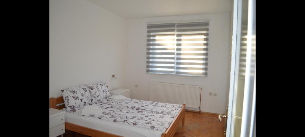 a small bedroom with a bed and a window at Apartman Linera in Soko Banja