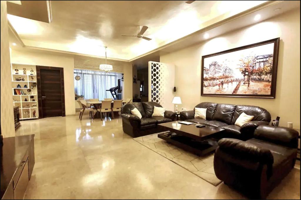 a living room with leather furniture and a dining room at House 40 - Strictly Parties and Noise not allowed, read house manual before booking in Pune