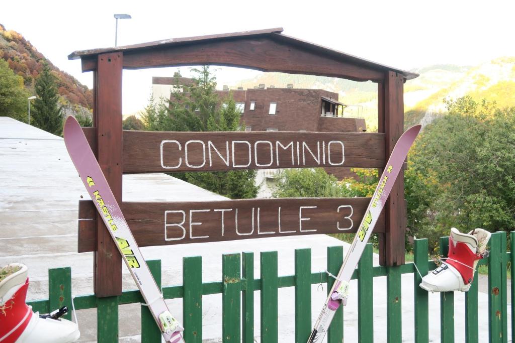 a sign that says colonino bella with skis on a fence at appartamento Artesina in Sella della Turra
