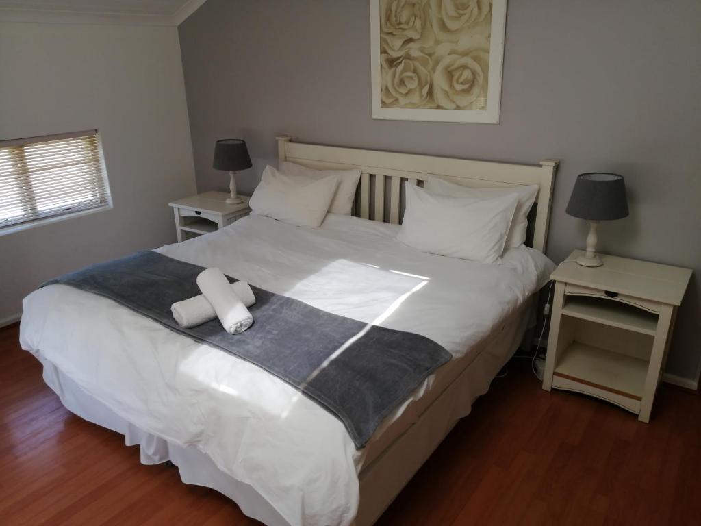 ein Schlafzimmer mit einem großen Bett mit weißen Laken und Kissen in der Unterkunft No 1 @ The Dunes in Plettenberg Bay