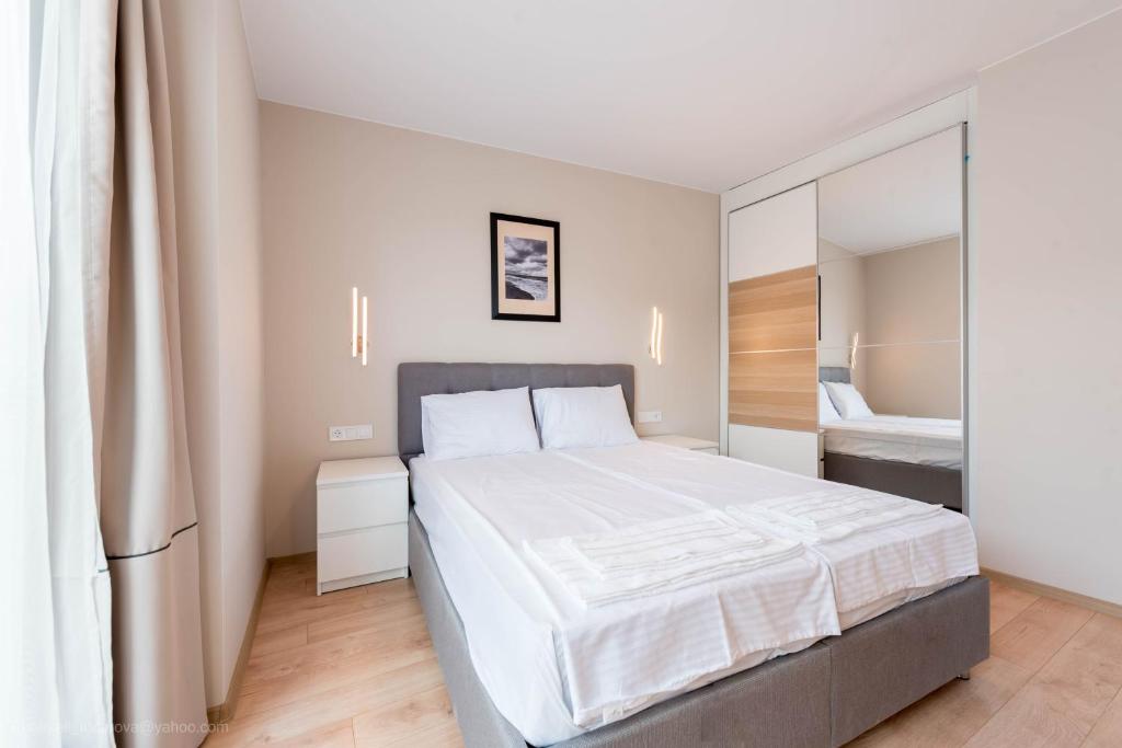 a bedroom with a large white bed in a room at Sea Stories Apartments Varna in Varna City