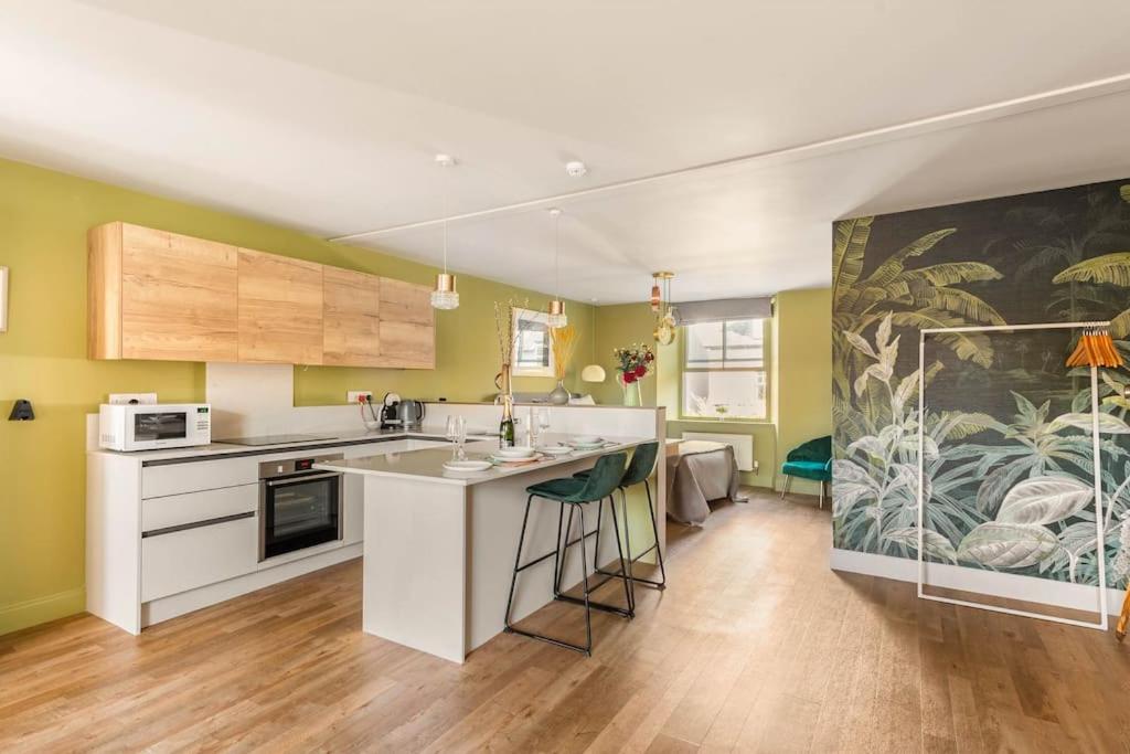 een keuken met groene muren en een groot schilderij bij Shamrock, Bowness on Windermere, Superb one bedroom apartment with private parking in Bowness-on-Windermere