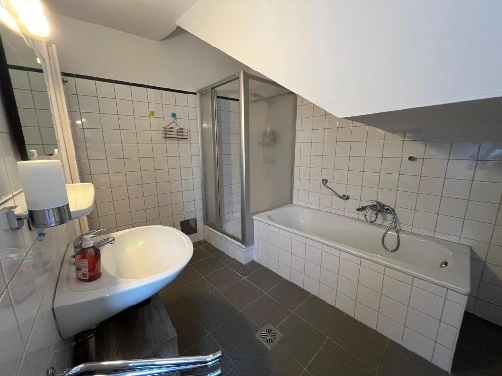 a bathroom with a tub and a sink and a bath tub at Hagmann&#39;s Altstadt Appartement in Krems an der Donau