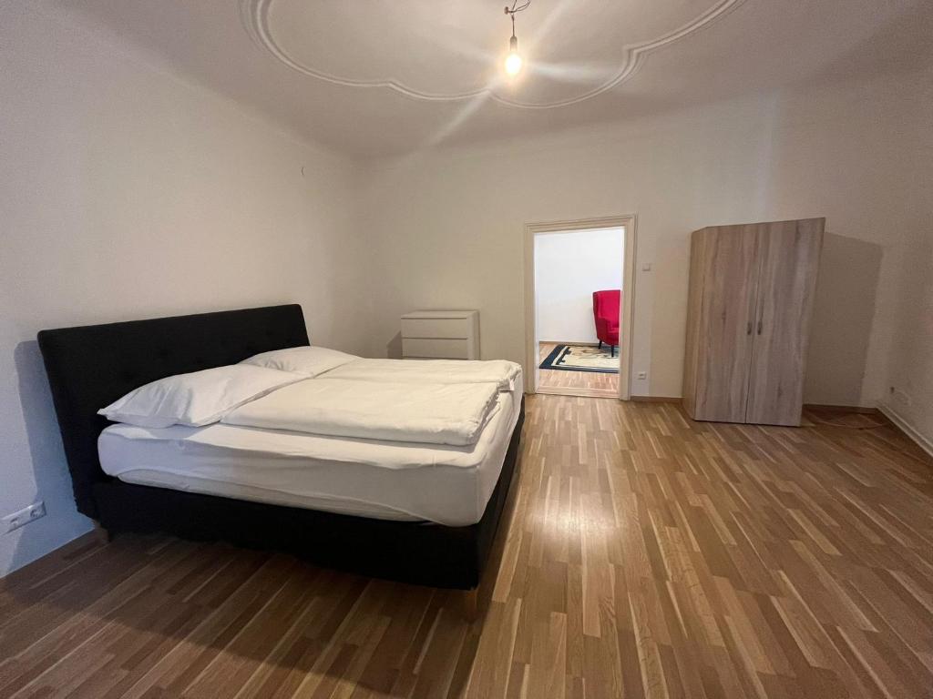 a bedroom with a large bed and a wooden floor at Hagmann&#39;s Altstadt Appartement in Krems an der Donau