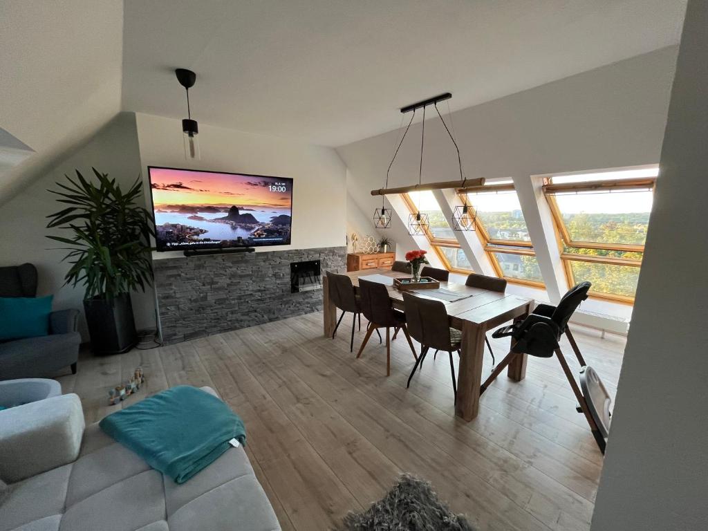 een woonkamer met een tafel en een tv aan de muur bij 105 QM neues klimatisiertes Appartment für Familien in Chemnitz