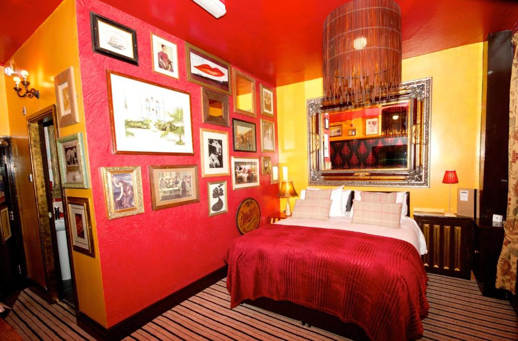 a red bedroom with a bed and pictures on the walls at Fifteens of Chester in Chester