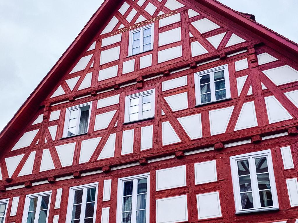 un edificio rojo y blanco con ventanas blancas en Ferienwohnung Dachstüble, en Blaubeuren