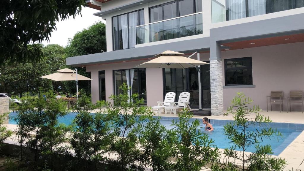 un niño en una piscina frente a una casa en Mangolia Farm, en San Juan
