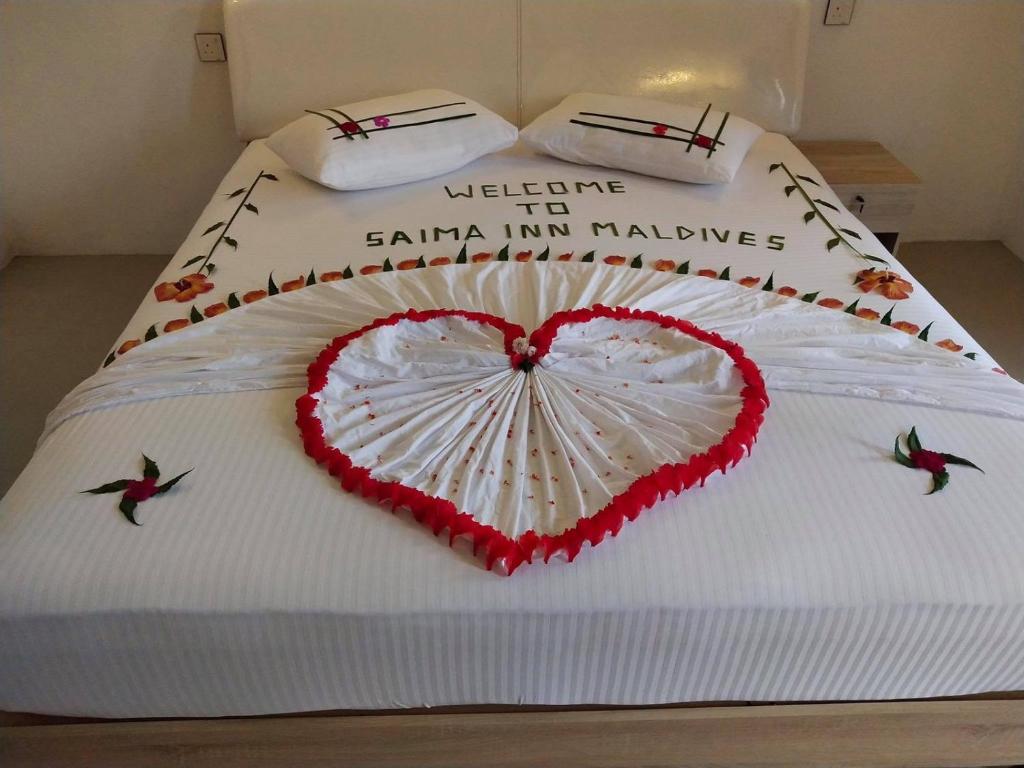a cake with a heart on top of a bed at Saima Inn in Maalhos