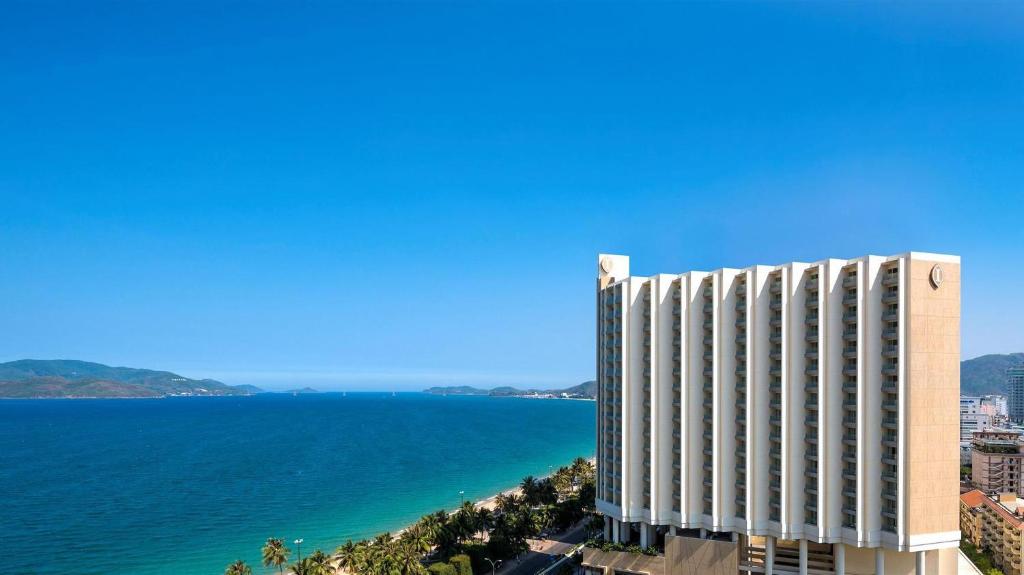 un edificio alto junto a un gran cuerpo de agua en InterContinental Nha Trang, an IHG Hotel, en Nha Trang
