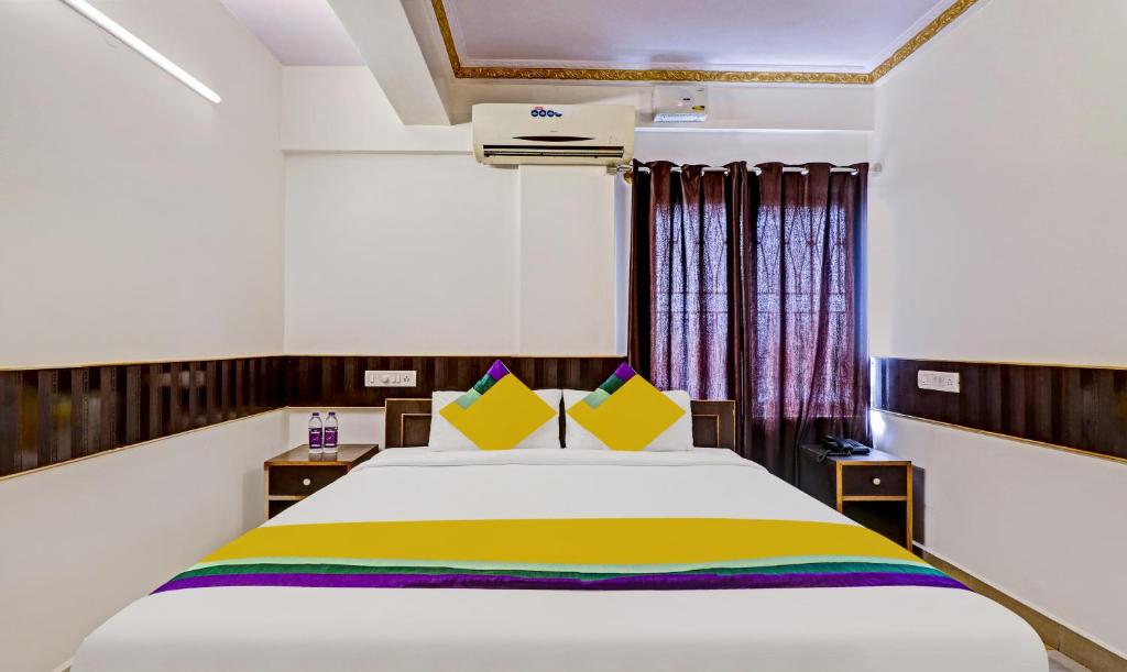 a bedroom with a large white bed with colorful sheets at Itsy By Treebo - HSR Comfort in Bangalore