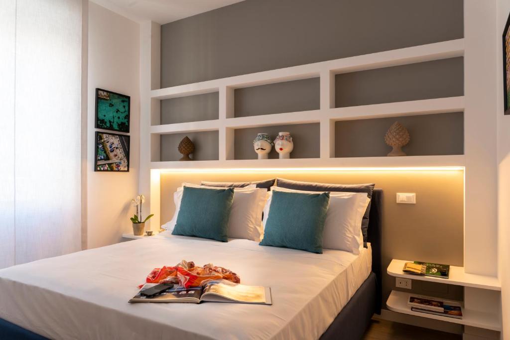 a bedroom with a large white bed with blue accents at La Musa Apartments & Rooms in Palermo