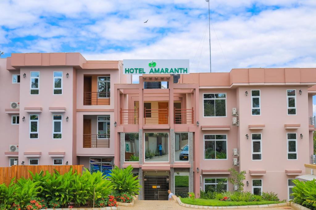 un edificio rosa con un cartello sopra di Hotel Amaranth a Dar es Salaam
