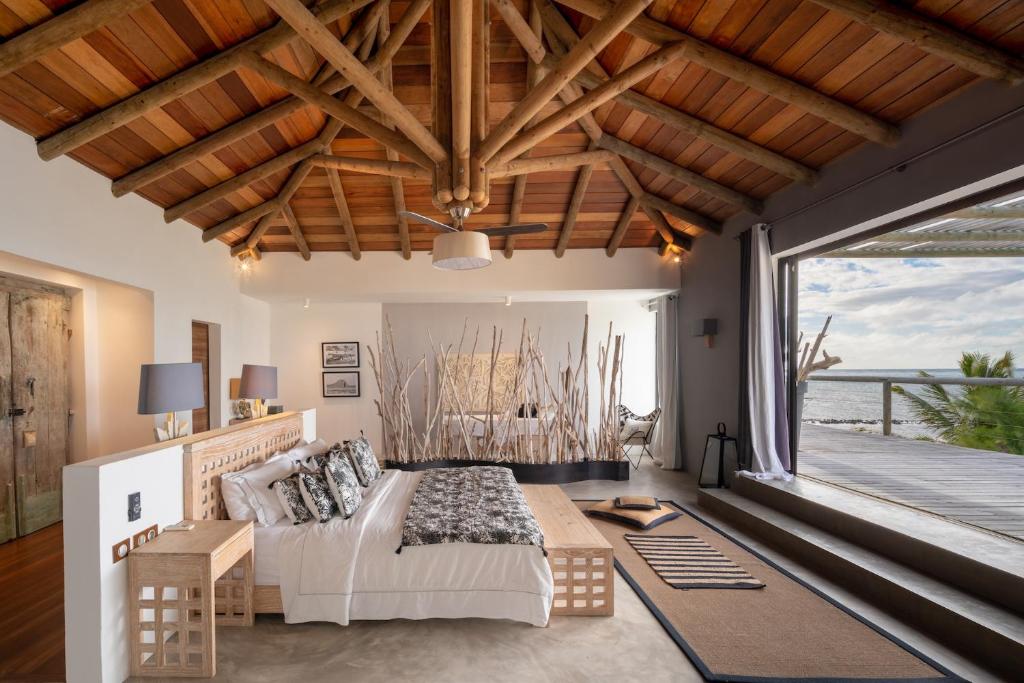 een slaapkamer met een bed en een groot raam bij Koki Bonheur by muse villas in Poste Lafayette