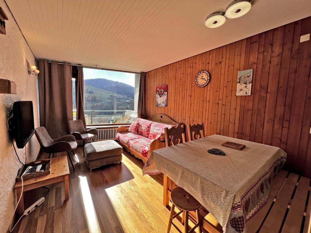 a living room with a table and a couch at Aravis 1500-11 - 2 pieces et coin nuit in La Clusaz