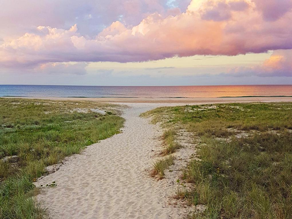 a path through the sand on a beach at Pacific Place Apartments in Gold Coast