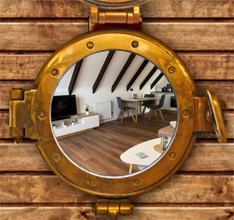 einen Spiegel an einer Holzwand mit einem Zimmer in der Unterkunft Lütt Huus 45 OG Horumersiel in Horumersiel