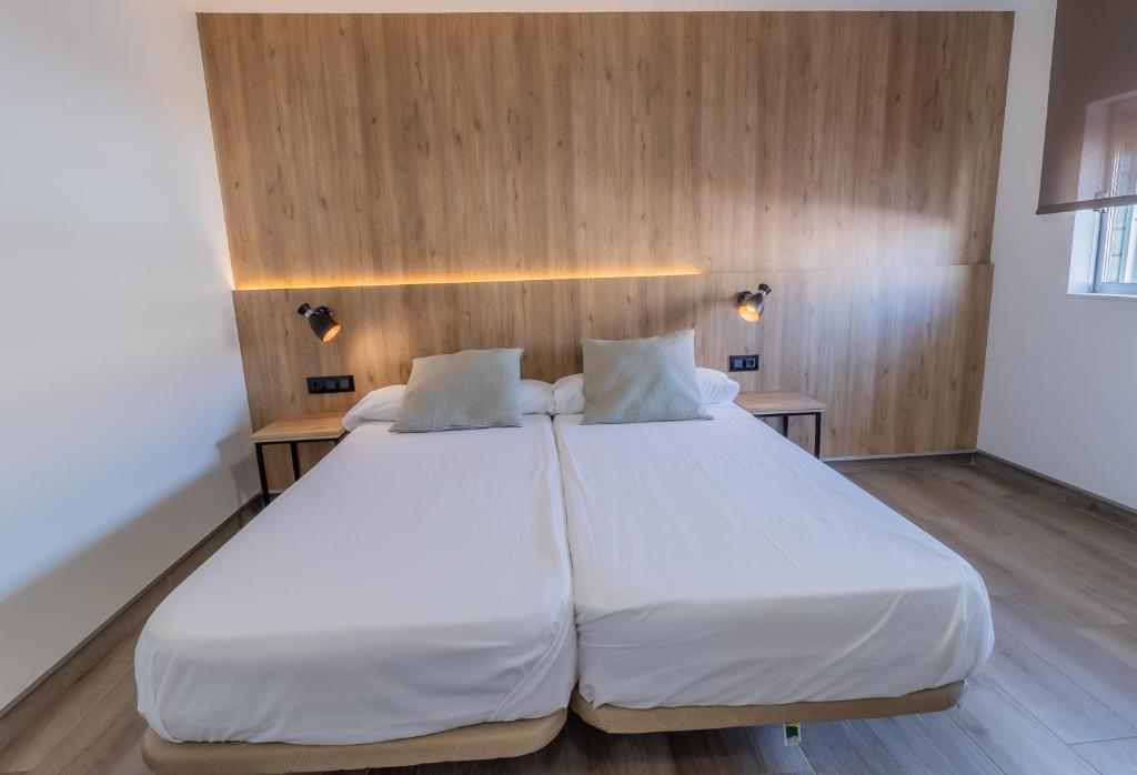 Habitación con 2 camas, paredes de madera y suelo de madera. en Hotel Kika en Santa Marta