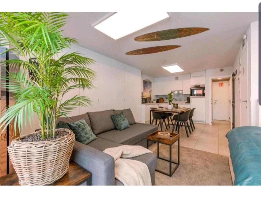 a living room with a couch and palm trees in it at CITY PREMIUM Studio Suite in Blankenberge